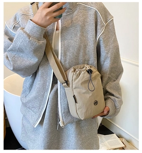 Adjustable wide shoulder strap detail on a compact waterproof nylon crossbody bag