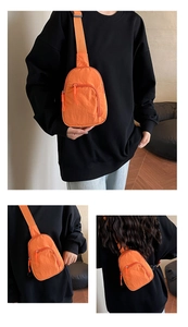 Détail du sac de poitrine en nylon orange vif avec bretelles réglables et compartiments