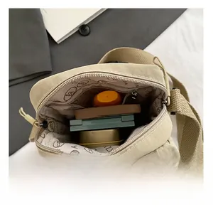 Interior view showing the large capacity and nylon lining of the beige crossbody bag