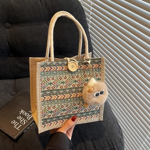 Ethnic knit tote bag with geometric patterns, wooden button and plush charm accessory