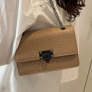 Chic brown woven shoulder bag with dark metal chain strap and square buckle on model
