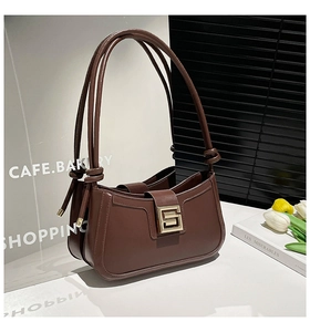 Detailed close-up of dark brown vintage leather handbag with a golden square metal buckle