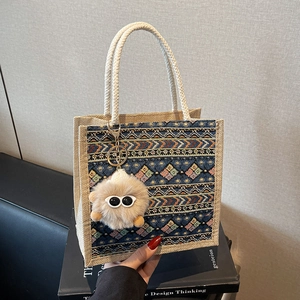 Ethnic woven tote bag with geometric patterns and plush eye charm for daily use
