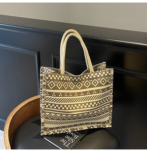 Close-up of geometric woven texture and thick rope handles on a large canvas tote bag