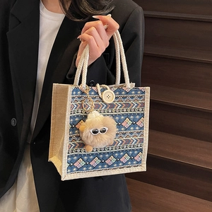 Ethnic bohemian tote bag with geometric knit pattern, rope handles and plush charm