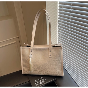 Detailed shot of retro floral jacquard tote bag with elegant tassel charm and strap
