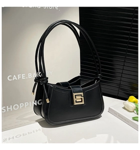 Detailed view of semi-moon leather shoulder bag with gold geometric G-lock and knot strap