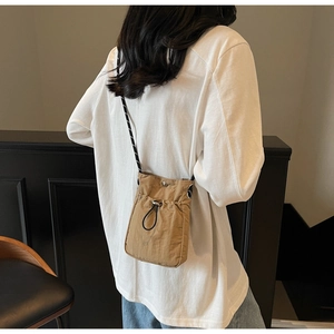 Khaki nylon crossbody phone bag featuring a drawstring closure and striped shoulder strap