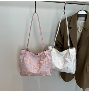 Detail of elegant shoulder bags featuring 3D butterfly floral textures in pink and white