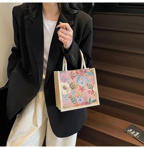 Florale Canvas-Tragetasche mit weißen Seilgriffen, präsentiert von einem Modell
