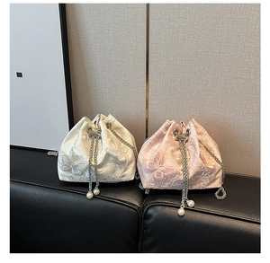 Detailed embroidery with pearl charms on white and pink drawstring bucket bags
