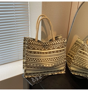 Detail of bohemian canvas tote bag with geometric patterns and rope handles in a room