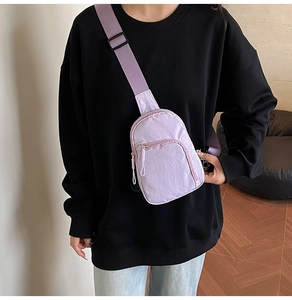 Détail du sac de poitrine en nylon violet avec sangle réglable et poches zippées