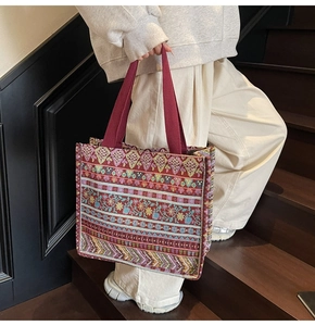 Close-up of bohemian woven tote bag with colorful geometric patterns and fabric handles