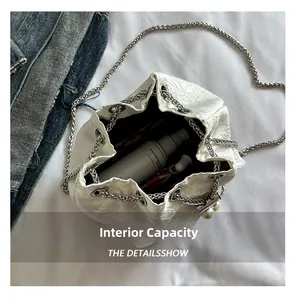Internal capacity of the white jacquard bucket bag showing cosmetics storage space