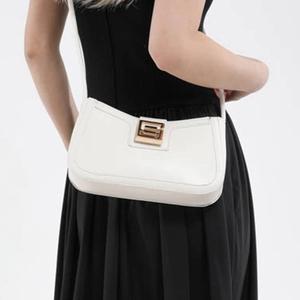 Minimalist white leather shoulder bag with gold S-buckle shown on model for daily commute