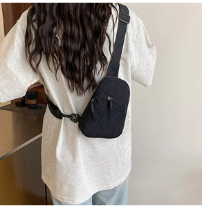 Détail d'un sac de poitrine en nylon noir avec bandoulière réglable porté par un mannequin