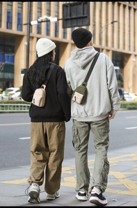Outdoor street view of compact nylon crossbody bags in beige and green for daily sport