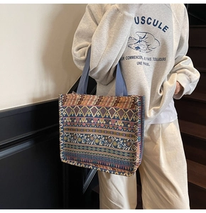 Detail of vintage bohemian tote bag with geometric patterns and blue woven shoulder strap