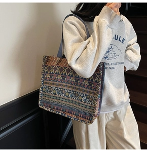 Detail of bohemian tapestry tote bag showing intricate woven patterns and wide blue strap
