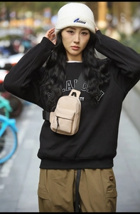 Detail of waterproof beige sling bag with adjustable strap and tactical buckle design