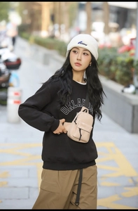 Close-up of lightweight waterproof beige crossbody bag styled with trendy streetwear outfit