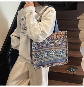 Close-up of bohemian tote bag featuring intricate ethnic patterns and woven blue straps