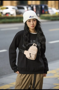 Fashionable beige nylon crossbody bag styled with a casual streetwear outfit and knit beanie