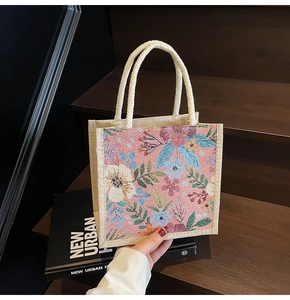 Nahaufnahme der rosa Leinentasche mit Blumenjacquard und weißen Baumwollseilgriffen