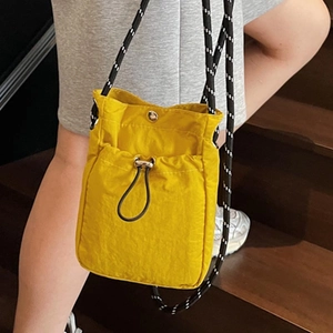Lightweight yellow nylon crossbody phone bag with drawstring and woven shoulder strap