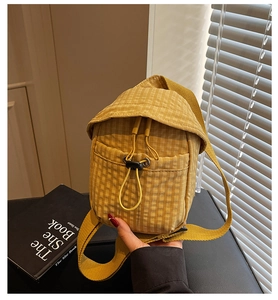 Detail of yellow checkered canvas crossbody bag with zipper pocket and adjustable strap