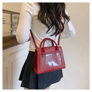 Détail d'un sac à bandoulière vintage rouge avec fenêtre carrée transparente et sangle