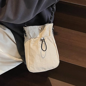 Minimalist cream crossbody mobile phone bag with black adjustable drawstring and metal buckle