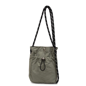 Green nylon mini bucket bag with drawstring and woven shoulder strap in outdoor style