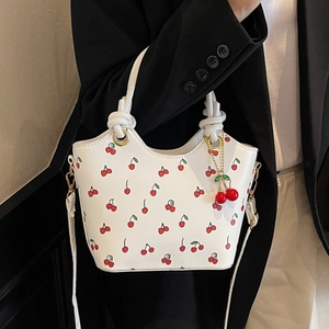Sac à bandoulière blanc rétro avec imprimé cerise et breloque cerise sur le mannequin