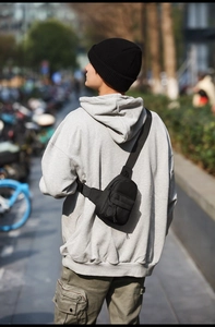 Detail of adjustable wide shoulder strap on black waterproof nylon crossbody bag for women