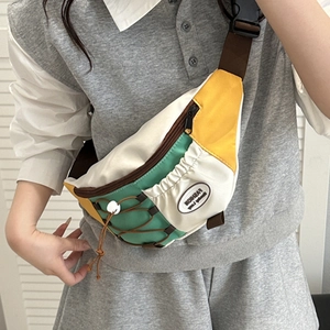 Sac bandoulière en toile tricolore avec détails jaune et vert porté par un modèle