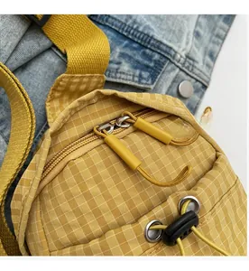 Detail of yellow checkered crossbody bag showing the smooth dual zipper closure system