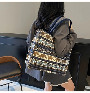 Detail of large canvas tote bag with ethnic elephant pattern worn on the shoulder