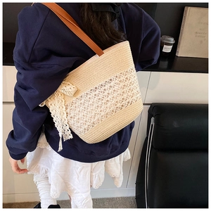Detail of striped straw tote with hollow mesh, lace bow and brown leather strap