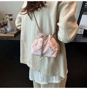 Detail showing pink lace bucket bag with 3D butterfly embroidery and pearl drawstring