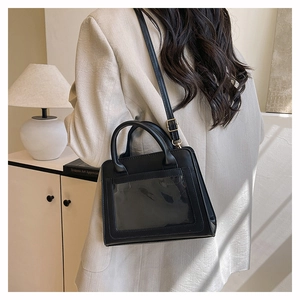 Vue détaillée du sac à bandoulière noir avec fenêtre transparente et boucles dorées