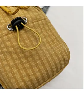 Detailed macro view of yellow checkered fabric with elastic drawstring and toggle fastener