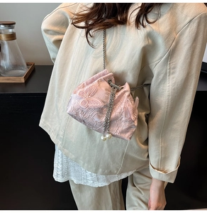 Close-up of pink bucket bag featuring delicate lace embroidery and 3D butterfly details