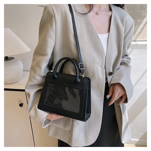 Détail d'un sac à bandoulière noir rectangulaire avec une fenêtre avant transparente
