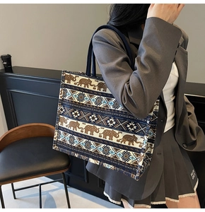 Large canvas tote bag featuring elephant prints and geometric patterns shown on shoulder