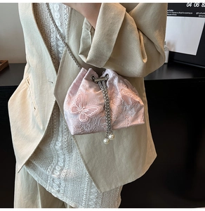 Close-up of pink bucket bag with floral lace embroidery and 3D butterfly detail