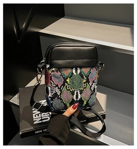 Detail of a mini crossbody bag featuring black PU leather and colorful snakeskin texture