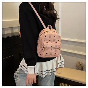 Gros plan du sac à dos rose tendance avec motif d'ours et détails de fermeture éclair dorée