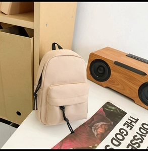 Close-up of beige waterproof canvas mini backpack bag with black drawcord zippers